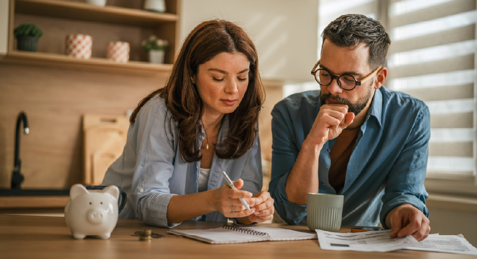 Pareja revisando finanzas con libreta y facturas