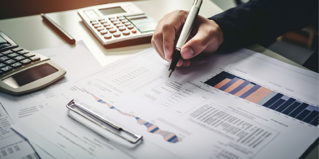 Persona revisando reporte financiero con calculadora y gráficos