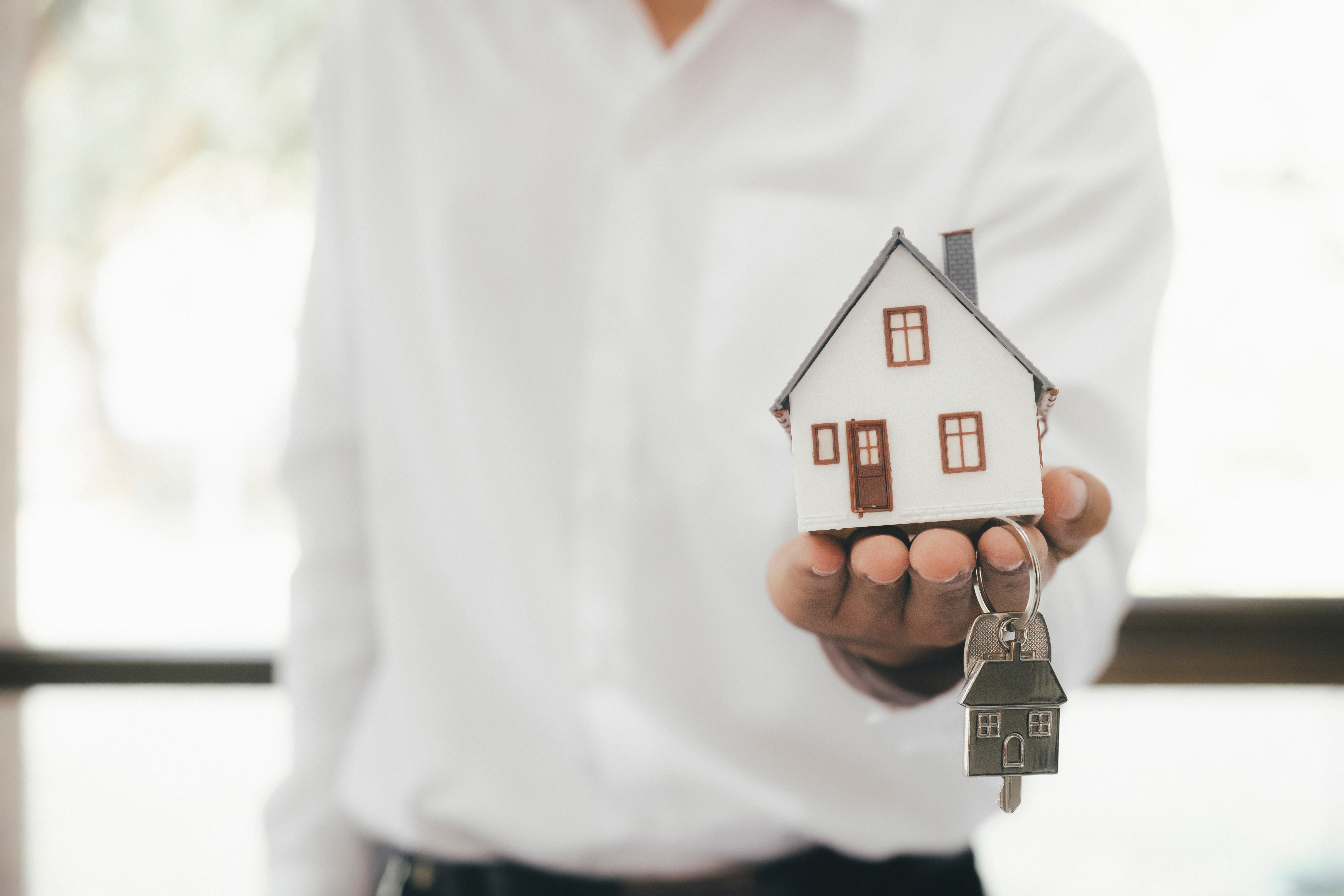 Ícono de persona con una casa y llaves en las manos